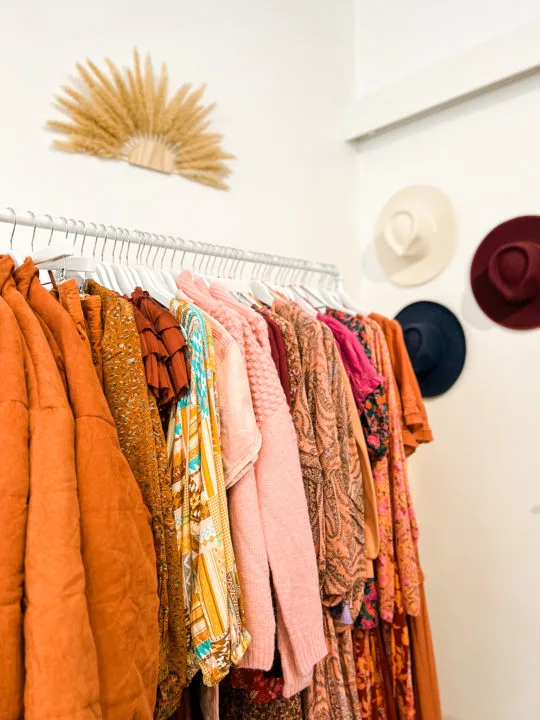 A rack of orange- and blush-colored clothes inside Flower Wild