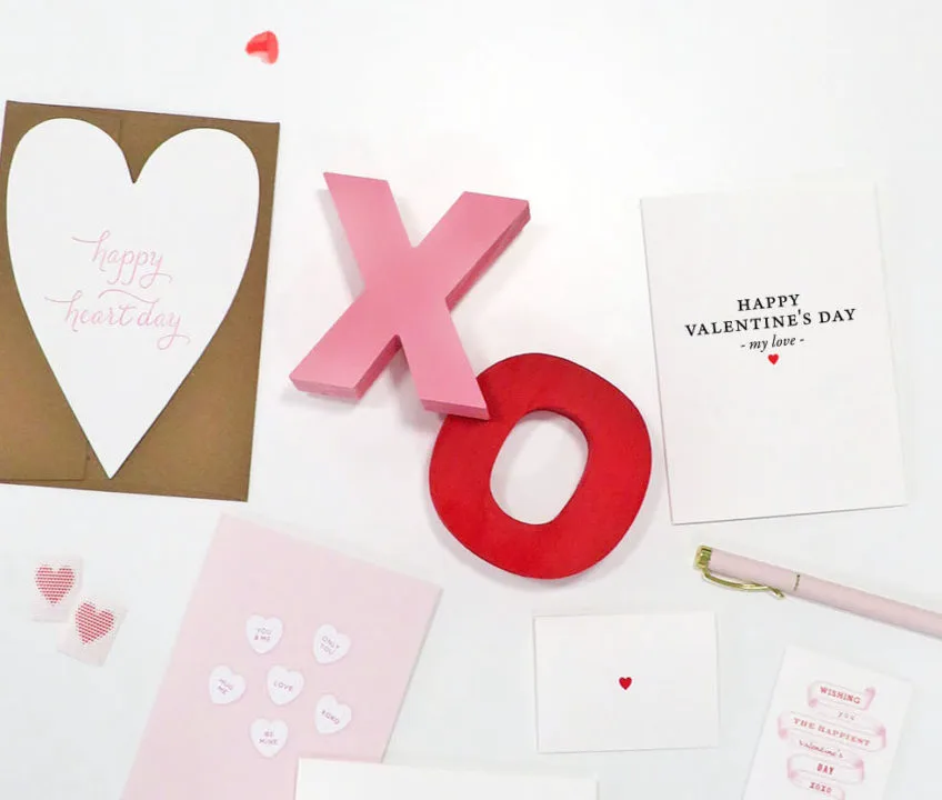 Valentine's Day cards staged with the letters "X" and "O" on a flat surface from paper shop Idea Chíc.