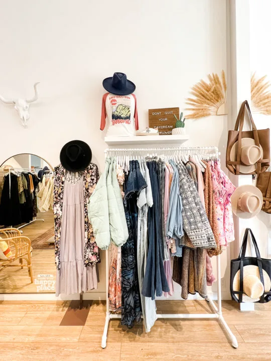 A rack of clothes and hats and accessories inside the Flower Wild storefront on Pearl Street in Boulder