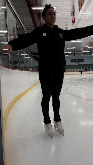 An ice skating coach shows how to march in place on ice skates.