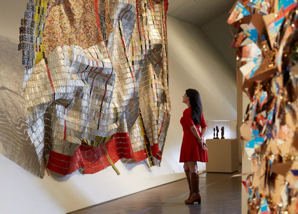 A woman admires a large metallic sculpture inside the Denver Art Museum