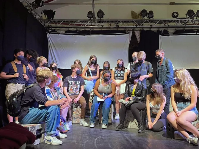 The cast of re:ACTION gathers on stage.
