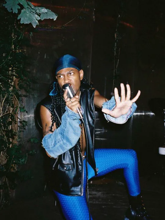 Denver pop artist N3ptune singing into a handheld microphone