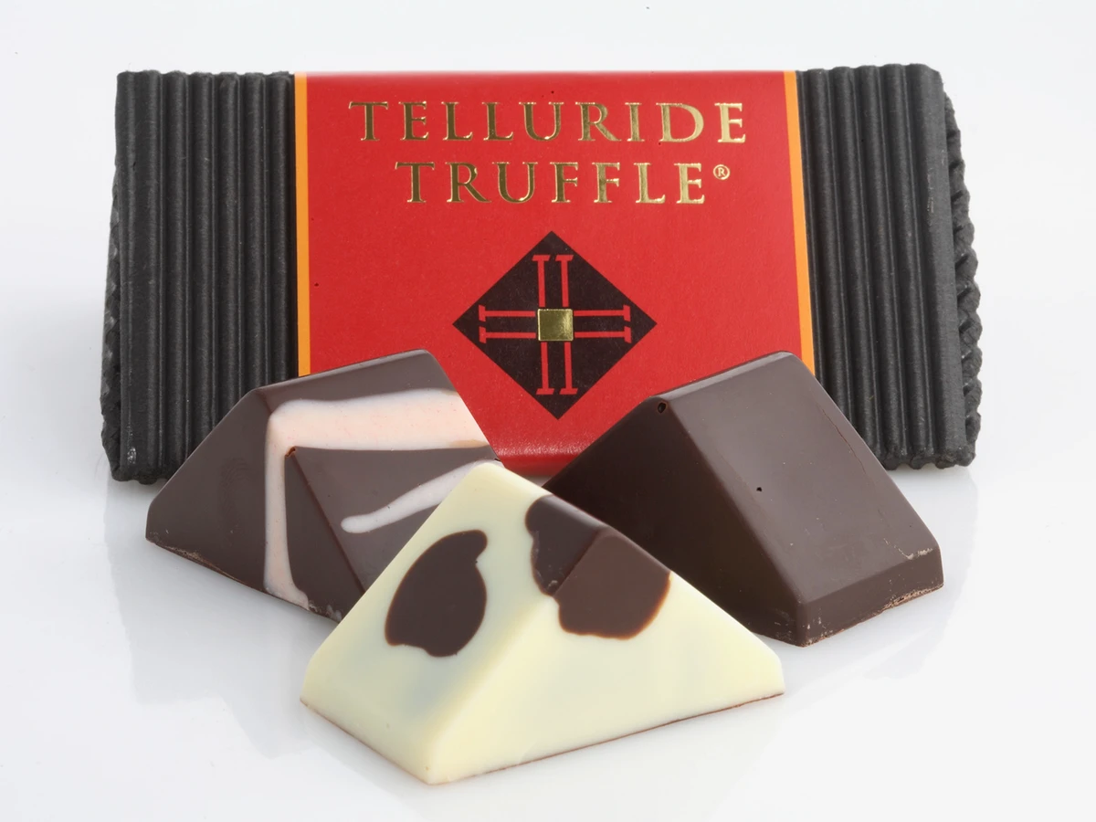 Three truffles sit in front of a Telluride Truffle box